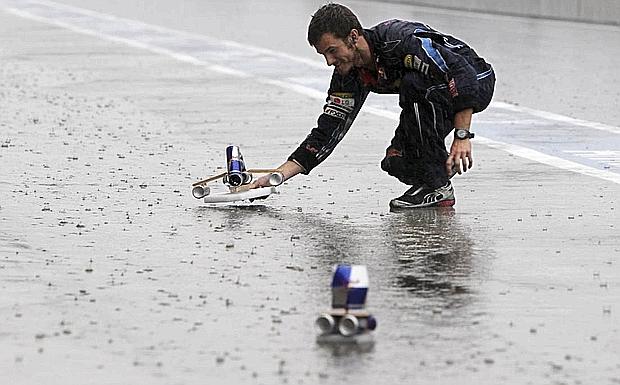 Un meccanico Red Bull fa galleggiare una barchetta costruita con le lattine dell'omonima bevanda